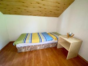 a small bedroom with a bed and a table at Apartmány Alma in Vyhne