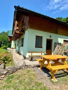 a house with two picnic tables in front of it at Apartmány Alma in Vyhne