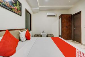 1 dormitorio con 1 cama grande con almohadas rojas en Super OYO Hotel 7 Sky, en Ludhiana