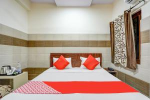 a bedroom with a bed with red pillows at Super OYO Hotel 7 Sky in Ludhiana