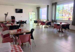 a restaurant with tables and chairs and a large room at Hotel Vilas in Salinópolis