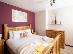 um quarto com uma cama grande e paredes roxas em Pass the Keys Private Entrance GF 2 bed flat near Renfrew Centre em Renfrew