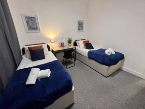 a hotel room with two beds and a desk at Stay - The Wellington Burton on Trent in Burton upon Trent