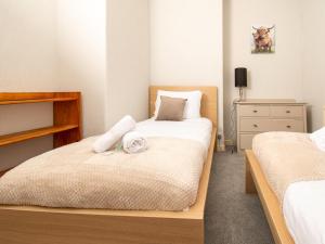 um pequeno quarto com 2 camas e uma cómoda em Pass the Keys Private Entrance GF 2 bed flat near Renfrew Centre em Renfrew