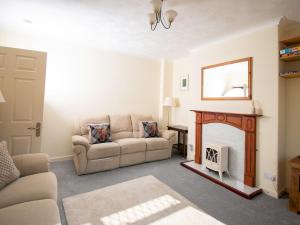 a living room with a couch and a fireplace at Pass the Keys Private Entrance GF 2 bed flat near Renfrew Centre in Renfrew