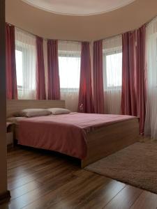 1 dormitorio con 1 cama grande y cortinas rojas en УЗВАР, en Bobrka
