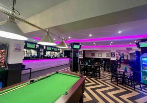 a pool table in a gaming room with pink lighting at Rhyl, Wales, CHESTNUT GARDENS Cost road Rhyl in Meliden