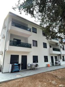 a large white building with a table in front of it at Villa Natalija in Nečujam