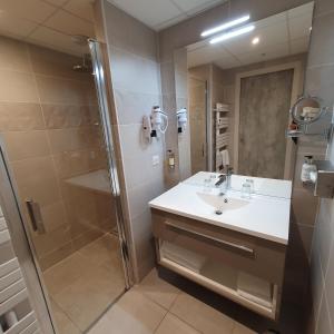 a bathroom with a sink and a shower at Logis Hotel La Closerie in La Baule