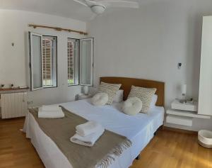 een slaapkamer met een groot wit bed en handdoeken bij Maison cosy au pied du golf in Muntanya la Sella