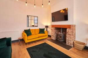 ein Wohnzimmer mit einem gelben Sofa und einem Kamin in der Unterkunft Host & Stay - Darcey House in Scarborough