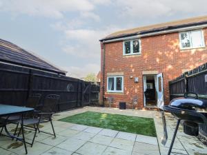 a patio with a table and chairs in front of a house at 19 Windsurfing Place in South Hayling