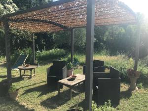 een pergola met stoelen en een tafel in de tuin bij Au son des cigales in Avignon