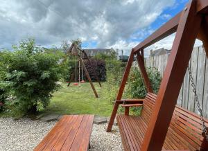 a swing set in a yard with a playground at Columba House in Inverness