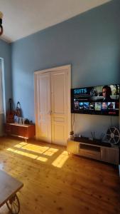 a living room with a television on a blue wall at Yellow and blue relax house in Piraeus