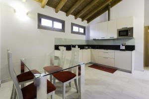 a kitchen with a glass table and chairs at Apartamentos Borizu Playa in Barro de Llanes