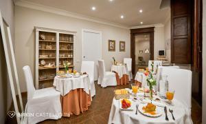 a dining room with white tables and white chairs at Albergo Diffuso Birkin Castello in Cagliari