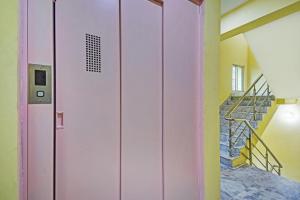 a pink door in a room with stairs at Hotel O Maa Residency Near Biswa Bangla in Thākurdwari +32 photos
