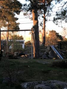 a fence and a tree in a yard at Sørlandsidyll nær by og Dyreparken in Grimstad