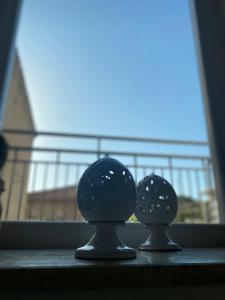two black glass spheres sitting on a window sill at DomusEli in Santa Maria di Castellabate