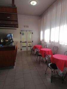 a room with tables and chairs with red table cloths at Hotel Holiday in Giulianova