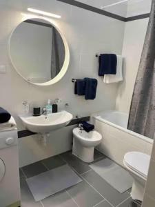 La salle de bains est pourvue d'un lavabo, de toilettes et d'un miroir. dans l'établissement Tivarnella B&B - Large and bright Attic in Trieste Center, à Trieste