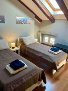 - une chambre avec 2 lits et une fenêtre dans l'établissement Tivarnella B&B - Large and bright Attic in Trieste Center, à Trieste