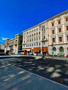 une rue vide devant un grand bâtiment dans l'établissement Tivarnella B&B - Large and bright Attic in Trieste Center, à Trieste