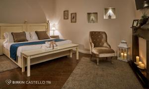 a bedroom with a bed and a chair at Albergo Diffuso Birkin Castello in Cagliari