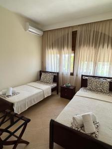 a hotel room with two beds and a window at Nikitihouse Apartments 1 in Nikiti