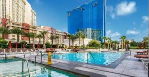una piscina en un complejo con sillas y edificios en MGM Signature PH 30th floor Deluxe Studio apartment Strip Facing with Balcony en Las Vegas