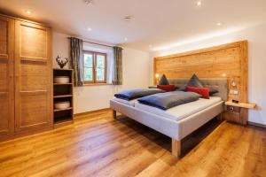 Schlafzimmer mit einem Bett mit einem Kopfteil aus Holz in der Unterkunft Ferienwohnung Schuhbeck in Ruhpolding