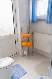 a bathroom with orange towels on a towel rack at Ferienwohnungen Christine Knoll in Bad Frankenhausen