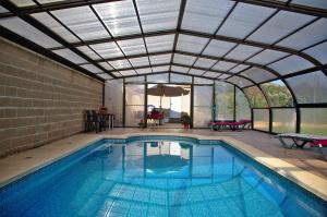 an indoor swimming pool with a glass ceiling at casa oliva la bodegueta in Abiego