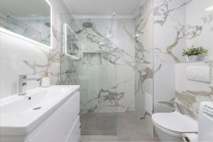 uma casa de banho branca com um lavatório e um WC em Blue Sky Apartment em Dubrovnik
