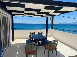 un tavolo e sedie su un balcone con vista sull'oceano di Annoula Studios and Apartments a Kardámaina