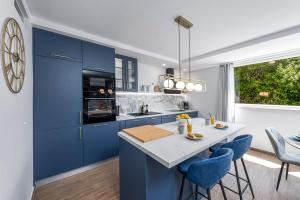 uma cozinha com armários azuis e uma mesa com cadeiras azuis em Blue Sky Apartment em Dubrovnik