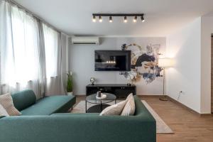 uma sala de estar com um sofá verde e uma televisão em Blue Sky Apartment em Dubrovnik