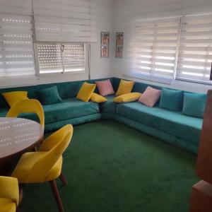 sala de estar con sofá azul y almohadas amarillas en Genial casa en centro, en Ceuta