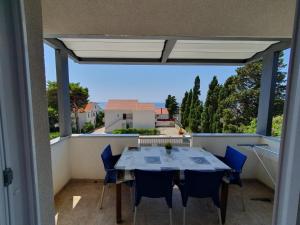 a patio with a table and chairs on a balcony at Villa Gaj in Novalja