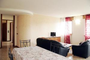 a room with a bed and a couch and a television at Bed&Wine in Negrar
