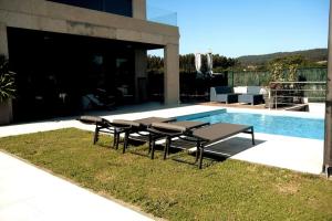 桑克森克索的住宿－Chalet de diseño moderno en Sanxenxo，一组在游泳池旁的野餐桌