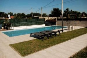 a swimming pool with benches next to a swimming pool at Chalet de diseño moderno en Sanxenxo in Sanxenxo