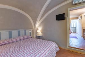 a bedroom with a bed and a tv on the wall at Residenza Gatteschi in Pistoia