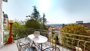 - un balcon avec une table et des chaises dans l'établissement Architectural gem with vintage charm, à La Chaux-de-Fonds
