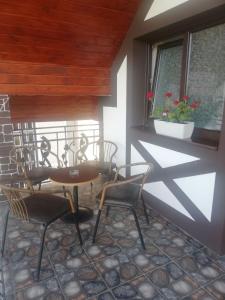 une véranda avec des chaises, une table et une fenêtre dans l'établissement Садиба АнноМарі - відпочинок в Карпатах котедж Яремче, à Yaremtche