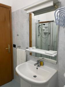 Baño blanco con lavabo y espejo en Casa Adalgisa, en Pianella
