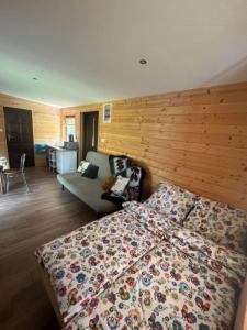sypialnia z łóżkiem i drewnianą ścianą w obiekcie Leśny Zakątek w Smardzewicach