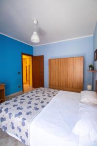 una camera da letto con un grande letto bianco e pareti blu di Caleidoscopica Bahlara Ballarò a Palermo