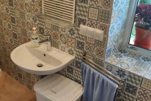 La salle de bains est pourvue d'un lavabo et de toilettes. dans l'établissement Rooms in Rodowe Siedlisko Lechja, 